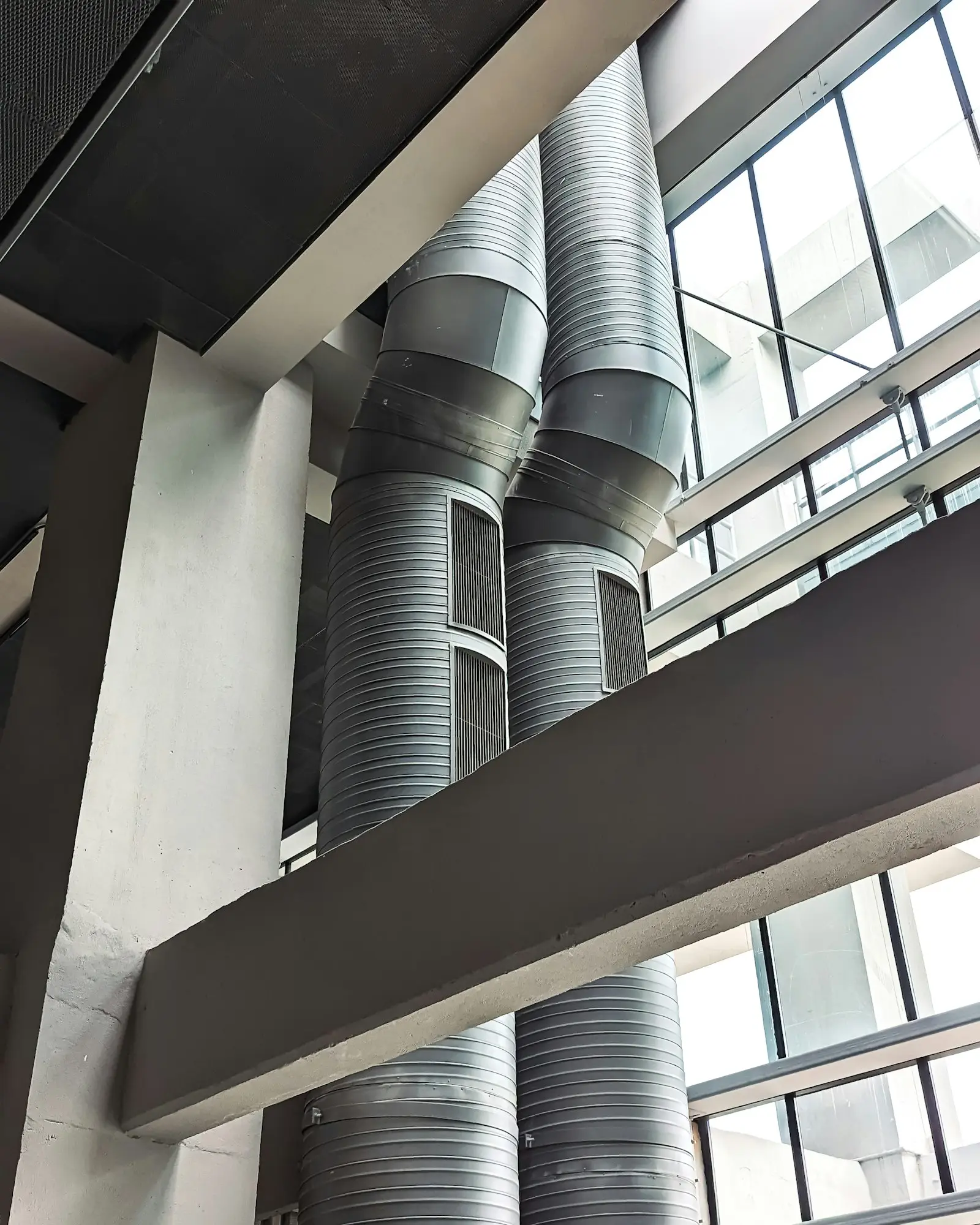Large spiral exhaust ductwork running through the ceiling of a commercial building