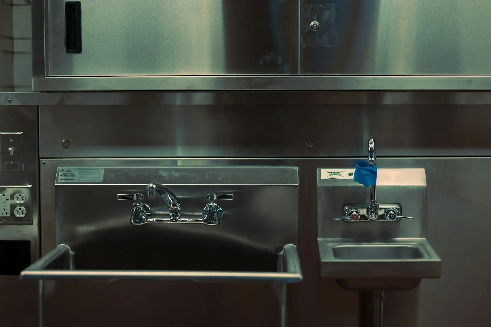 Stainless steel commercial kitchen bench and canopy in a professional venue