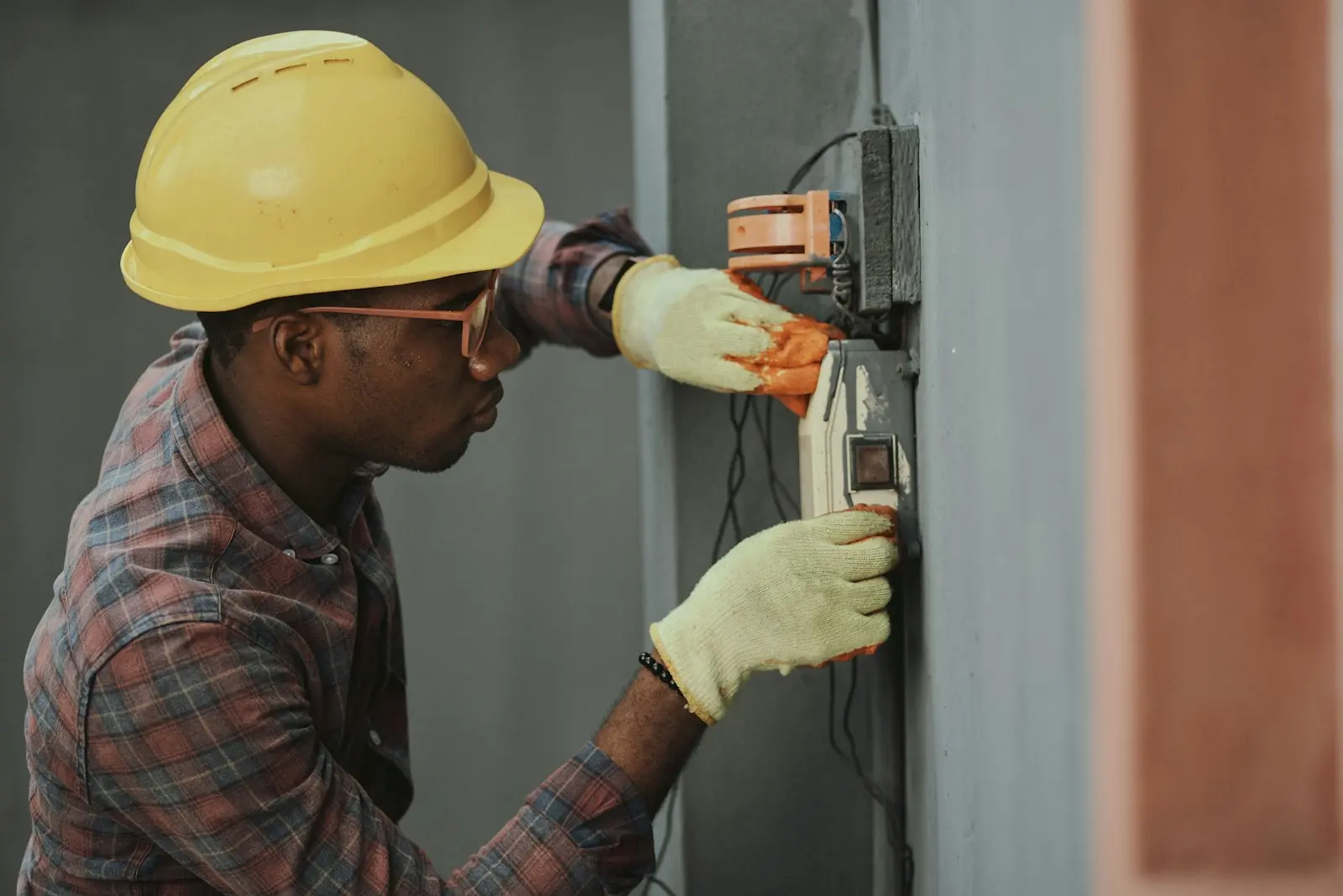 Technician in a hard hat servicing commercial mechanical equipment on site